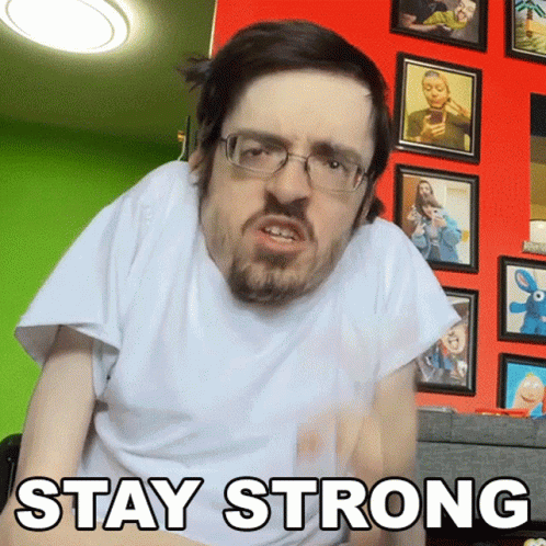 A Man Wearing Glasses And A White Shirt With The Words Stay Strong Written On It GIF