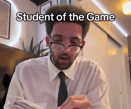 A Man Wearing Glasses And A White Shirt With The Words Student Of The Game Written On It GIF