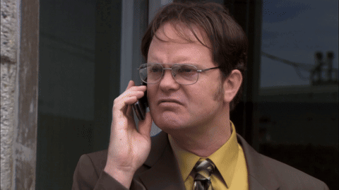 A Man Wearing Glasses And A Yellow Shirt Talks On A Cell Phone GIF