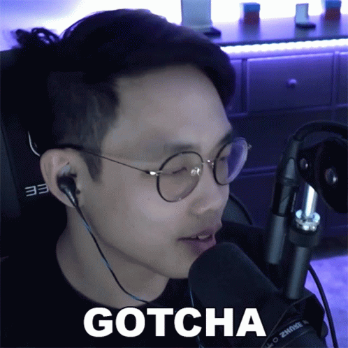 A Man Wearing Glasses And Ear Buds Says Gotcha GIF