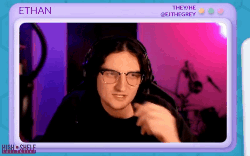 A Man Wearing Glasses And Headphones Is Sitting In Front Of A Screen With The Name Ethan On It GIF