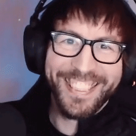 A Man Wearing Glasses And Headphones Is Smiling . GIF
