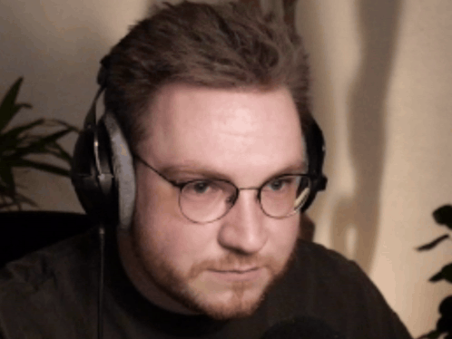 a man wearing glasses and headphones looks to his left