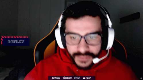 A Man Wearing Glasses And Headphones With A Replay Sign In The Corner GIF