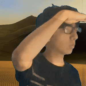 A Man Wearing Glasses Covering His Eyes In Front Of A Desert GIF