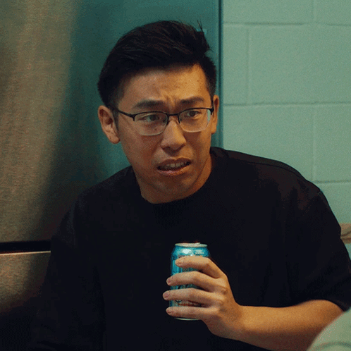 A Man Wearing Glasses Holds A Can Of Soda In His Hand GIF