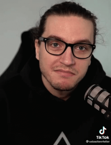 A Man Wearing Glasses Holds A Rode Microphone In His Hand GIF