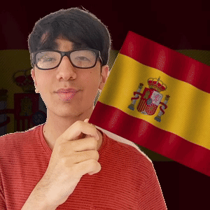 A Man Wearing Glasses Holds A Spanish Flag In Front Of Him GIF