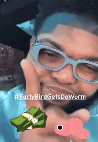 A Man Wearing Glasses Holds A Stack Of Money And A Worm GIF