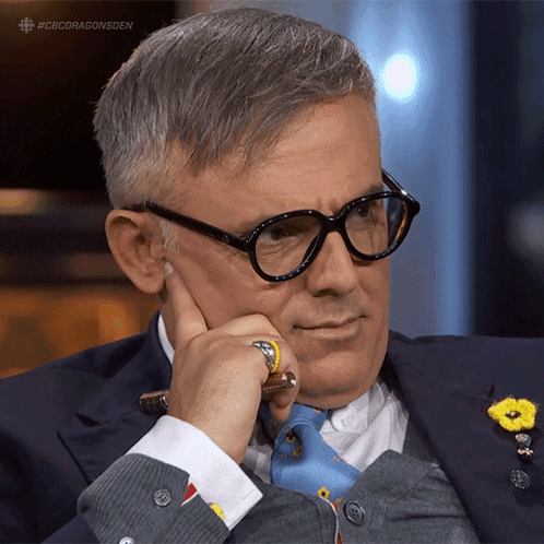 A Man Wearing Glasses Holds His Hand To His Chin With The Hashtag #Cbcdragonsden GIF