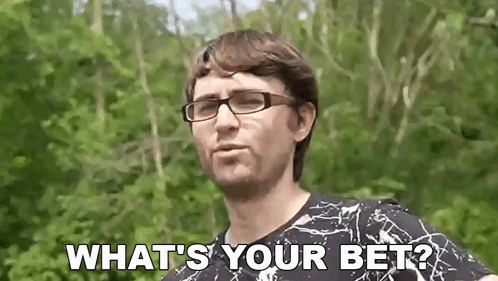 a man wearing glasses is asking what 's your bet while standing in front of trees .
