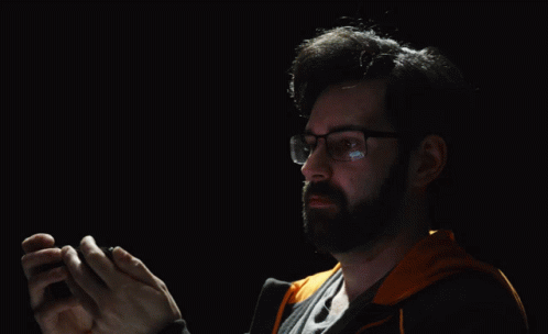 A Man Wearing Glasses Is Clapping His Hands In Front Of A Black Background That Says My Eyes GIF