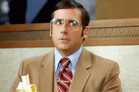 A Man Wearing Glasses Is Eating A Banana GIF