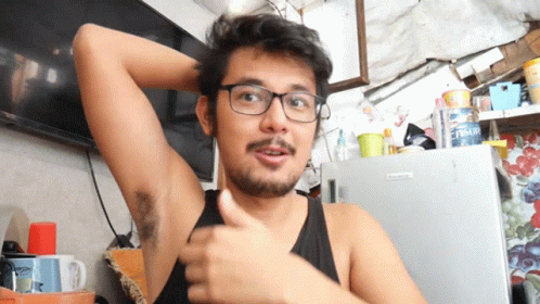 A Man Wearing Glasses Is Giving A Thumbs Up In Front Of A Fridge That Says ' Fresh ' On It GIF