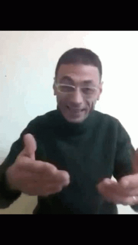 A Man Wearing Glasses Is Giving A Thumbs Up Sign . GIF