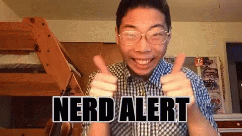 A Man Wearing Glasses Is Giving A Thumbs Up With The Words Nerd Alert Written On His Chest GIF