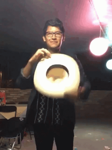 A Man Wearing Glasses Is Holding A Cowboy Hat In His Hand GIF