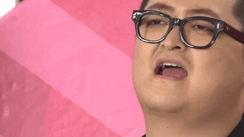 A Man Wearing Glasses Is Holding A Pink Umbrella And Making A Funny Face . GIF