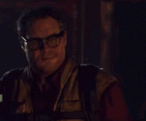 A Man Wearing Glasses Is Holding A Walkie Talkie GIF