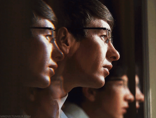 A Man Wearing Glasses Is Looking Out A Window And The Website Mndvx.tumblr.com Is Visible GIF