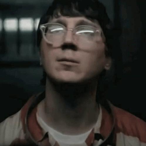 A Man Wearing Glasses Is Looking Up At Something GIF