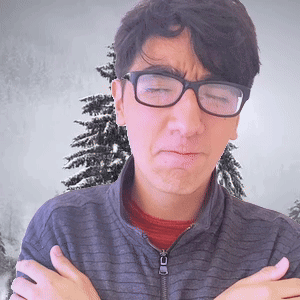 A Man Wearing Glasses Is Making A Face With His Arms Crossed In Front Of A Christmas Tree GIF
