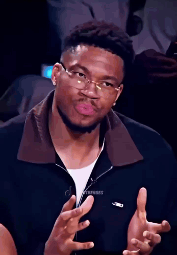 A Man Wearing Glasses Is Making A Funny Face GIF