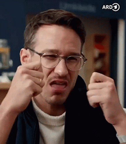A Man Wearing Glasses Is Making A Funny Face And Making A Funny Face . GIF