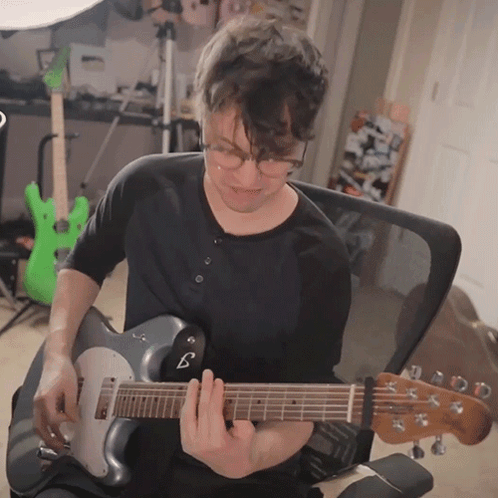 Man With Glasses Playing Guitar With B On Neck GIF