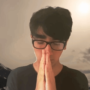 A Man Wearing Glasses Is Praying With His Hands Folded GIF