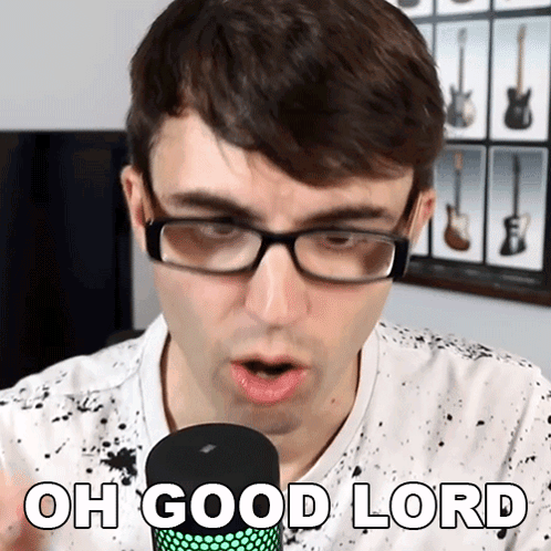 A Man Wearing Glasses Is Singing Into A Microphone With The Words Oh Good Lord Below Him GIF