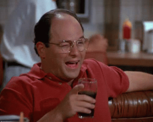 A Man Wearing Glasses Is Sitting At A Table Holding A Glass Of Soda . GIF