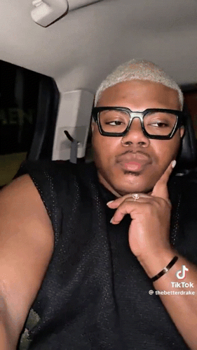 a man wearing glasses is sitting in a car