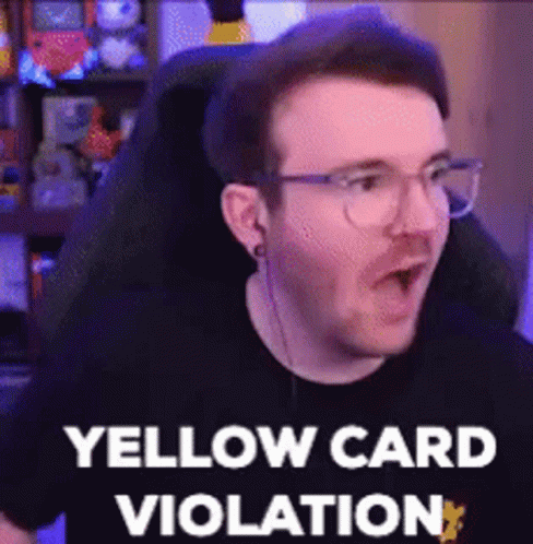 A Man Wearing Glasses Is Sitting In A Chair And Making A Funny Face While Saying Yellow Card Violation . GIF