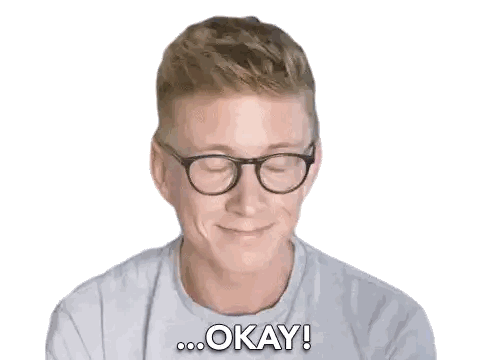 a man wearing glasses is smiling and saying " okay "