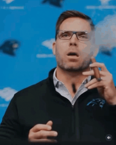 A Man Wearing Glasses Is Smoking A Cigar GIF