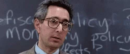 A Man Wearing Glasses Is Standing In Front Of A Blackboard That Says Bueller GIF