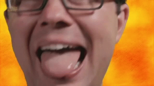 A Man Wearing Glasses Is Sticking His Tongue Out In Front Of A Yellow Background . GIF