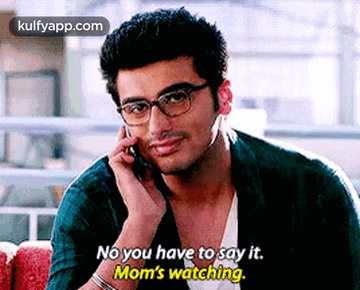 A Man Wearing Glasses Is Talking On A Cell Phone And Saying `` No You Have To Say It . Mom 'S Watching '' GIF
