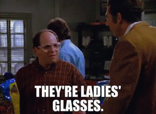A Man Wearing Glasses Is Talking To Another Man In A Kitchen . GIF