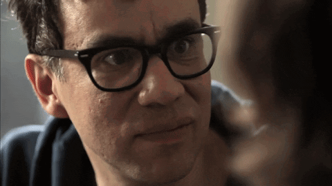 A Man Wearing Glasses Looks At Another Man GIF