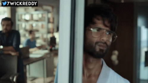 A Man Wearing Glasses Looks Out Of A Window With A Twitter Logo Above Him GIF