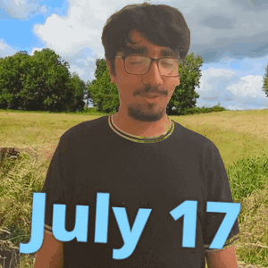 A Man Wearing Glasses Stands In A Field With The Date July 17 GIF