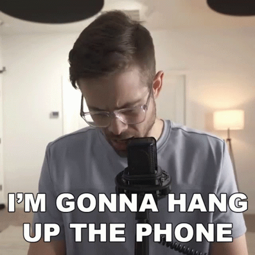 A Man Wearing Glasses Stands In Front Of A Microphone With The Words " I 'M Gonna Hang Up The Phone " Below Him GIF