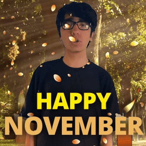 A Man Wearing Glasses Stands In Front Of A Sign That Says " Happy November " GIF