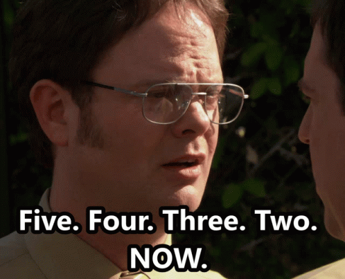 A Man Wearing Glasses Talks To Another Man With The Words Five Four Three Two Now Below Him GIF