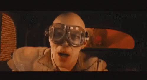 A Man Wearing Goggles Is Sitting In A Car And Making A Funny Face . GIF