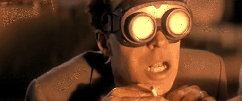 A Man Wearing Goggles Is Smoking A Cigarette And Making A Funny Face . GIF