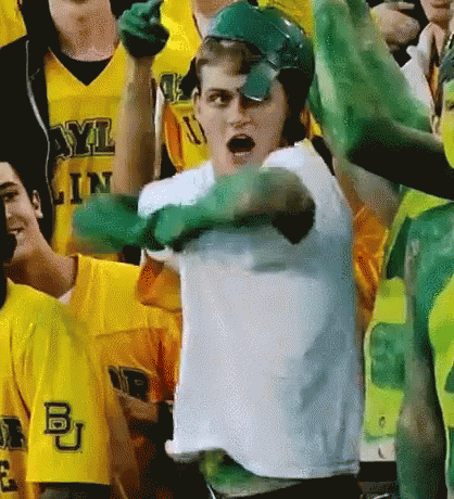 A Man Wearing Green Gloves And A White Shirt With The Letters Bu On It GIF
