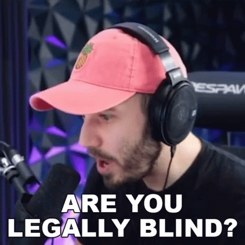 A Man Wearing Headphones And A Baseball Cap Is Talking Into A Microphone And Asking If He Is Legally Blind . GIF
